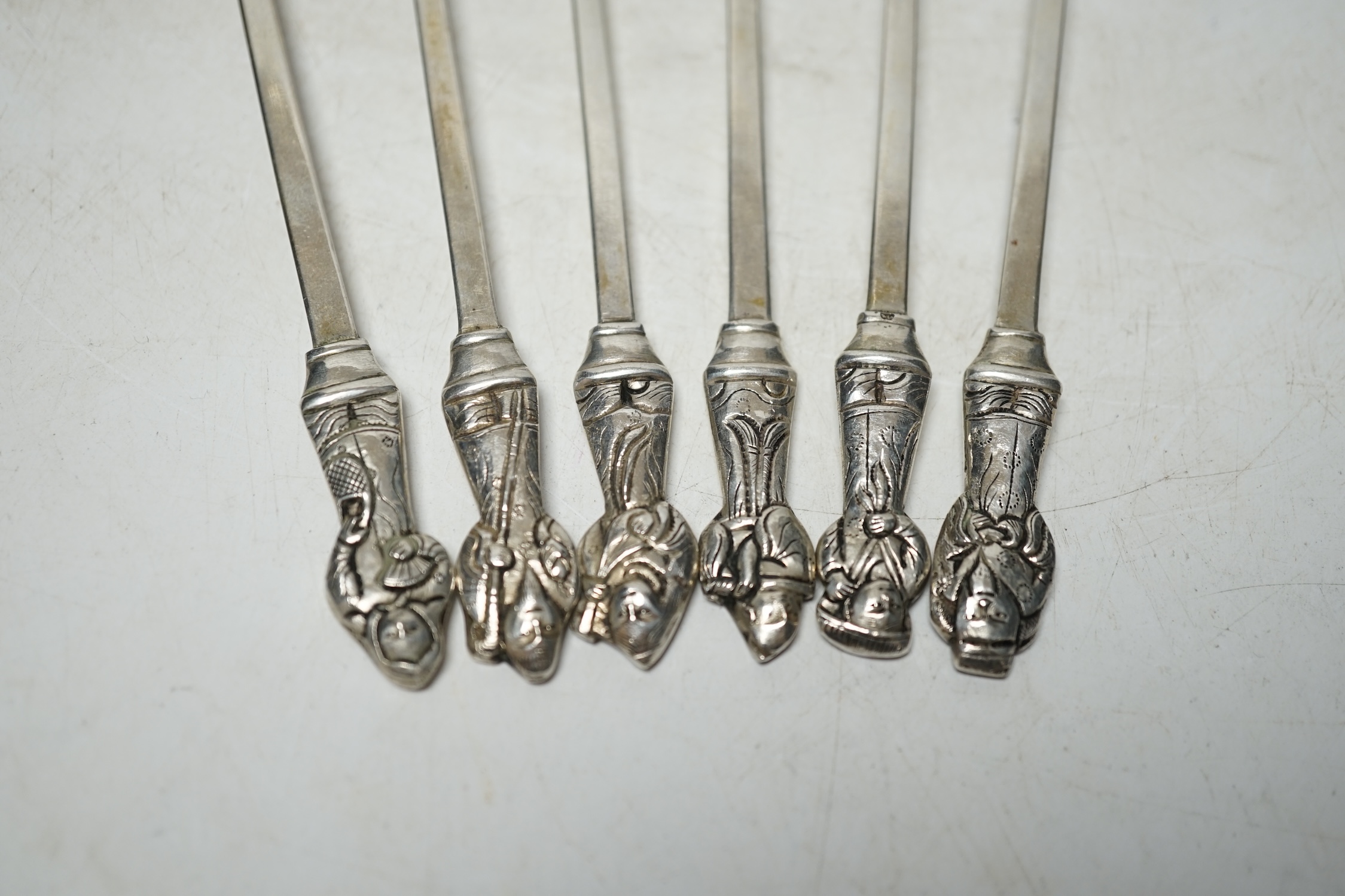 A set of six South American? white metal sundae spoons , each with figural finials, stamped 'Argent', 17.3cm, 121 grams. Condition - fair